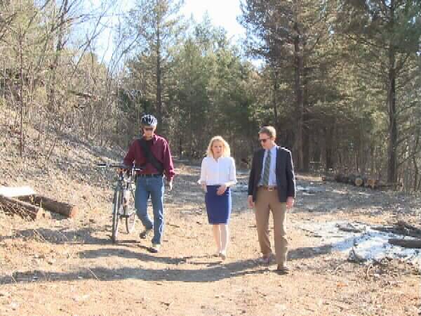 KOAM-TV reporter Stacey Lindsay walks with Lehigh Portland Trails volunteer Randy Rasa and Thrive Allen County Executive Director David Toland.